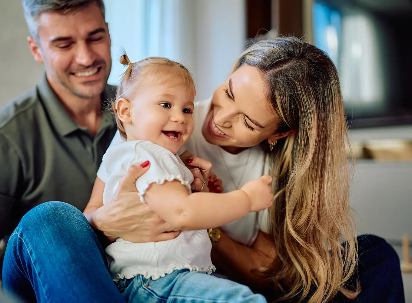 mother and father holding their toddler child